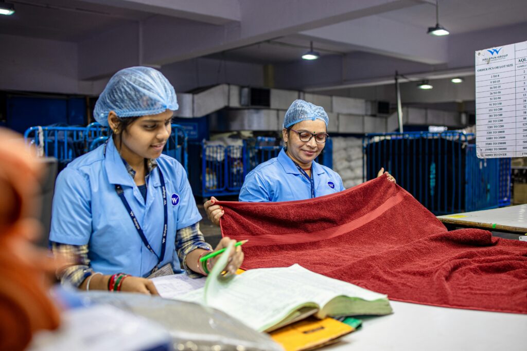pexels-photo-31030921-31030921 Two female textile workers inspecting red fabric in a factory setting.