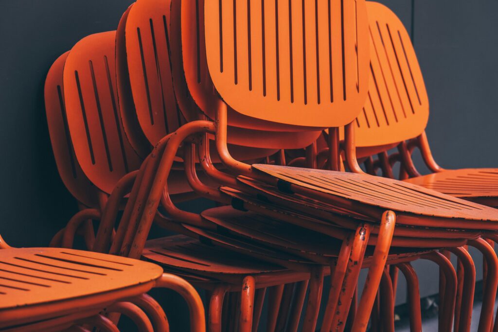 Close-up of stacked orange metal chairs with a modern design in İstanbul, Türkiye.