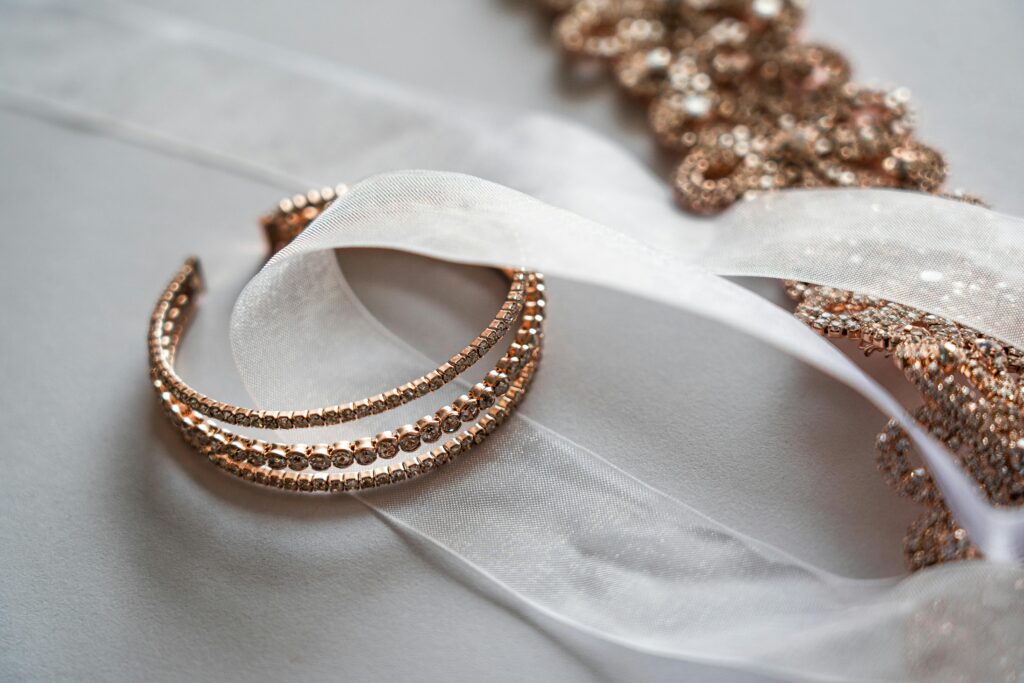 pexels-photo-3641059-3641059 Close-up of luxurious rose gold jewelry on a sheer satin fabric, perfect for bridal occasions.