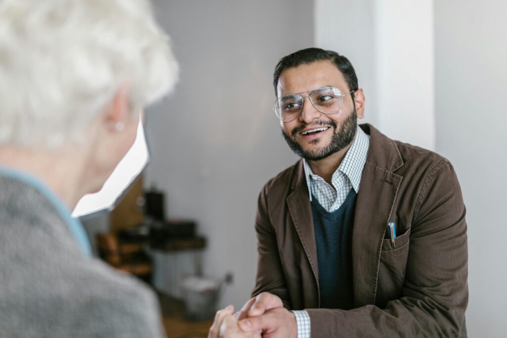 pexels-photo-7413995-7413995 Two business professionals engaged in a friendly handshake indoors.