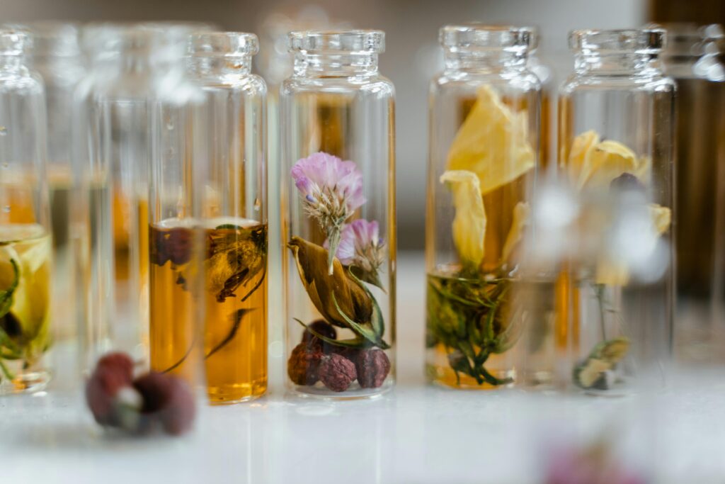 pexels-photo-8450212-8450212 Close-up of assorted dry flowers immersed in glass vials, ideal for natural fragrance products.