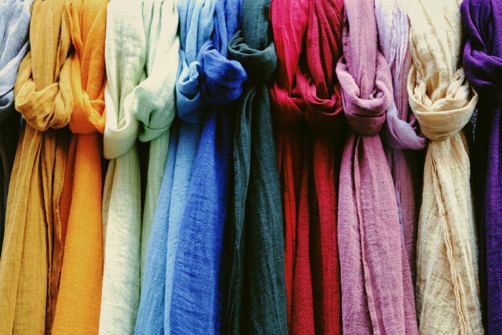 pexels-photo-4405941-4405941 A vibrant collection of multicolored scarves displayed in a market setting.